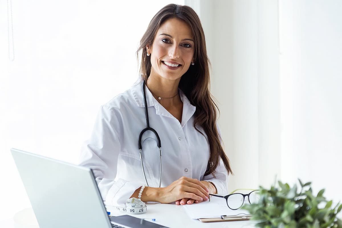 Profissional da saúde em frente ao computador para ensinar como montar uma clínica médica do zero.