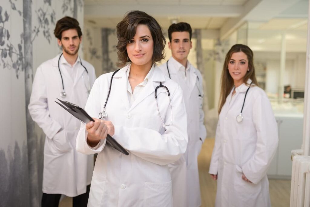 Profissionais da saúde reunidos com uma médica na frente, simbolizando como liderar uma equipe médica.