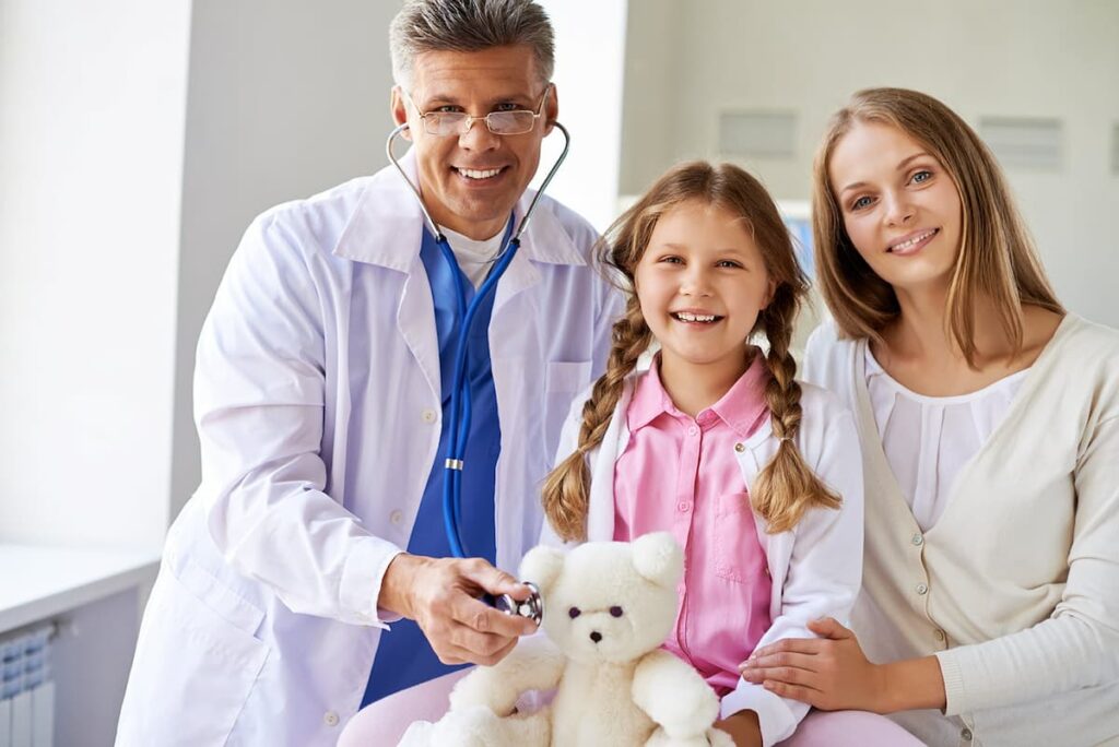 Médico com pacientes sorridentes, simbolizando como evitar queixas no consultório.