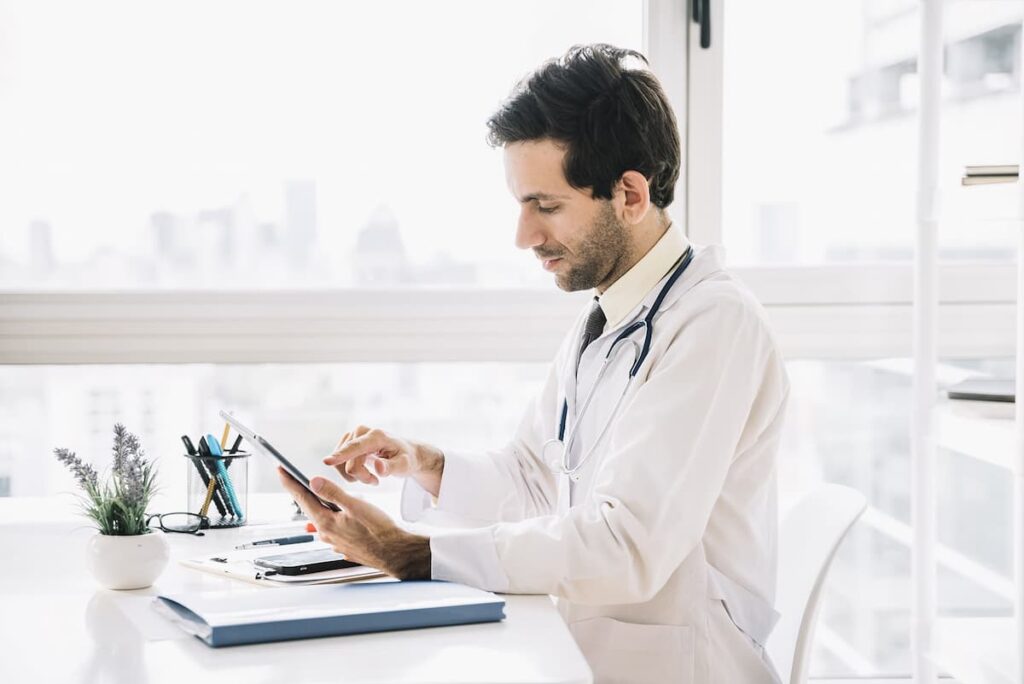 Médico fazendo um agendamento online no tablet.
