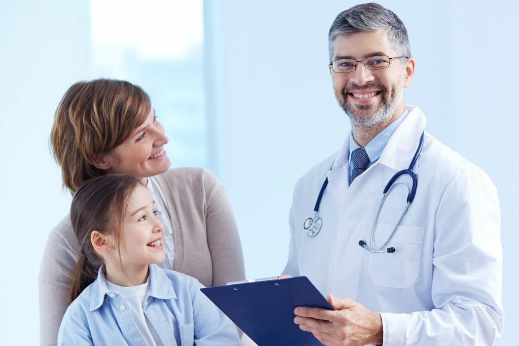 Médico sorrindo com pacientes, representando como atrair pacientes para clínicas médicas.