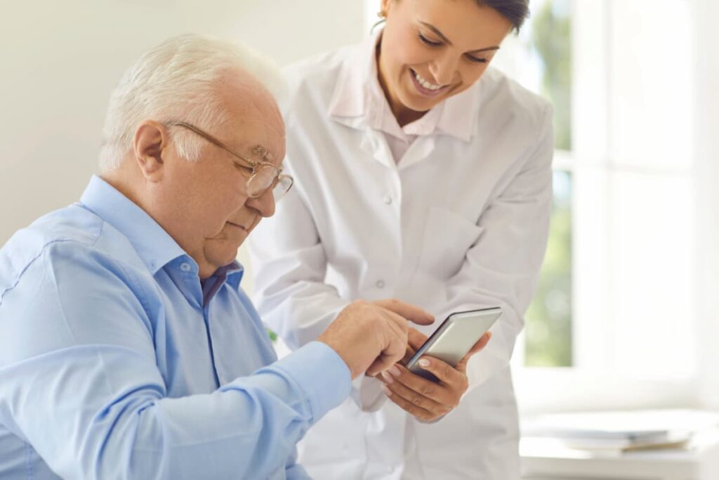 Médica demonstrando um celular com SMS para clínicas para o paciente.
