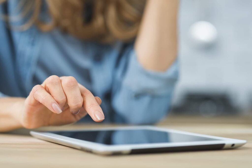 Médica fazendo agendamento online em tablet para sua clínica médica.