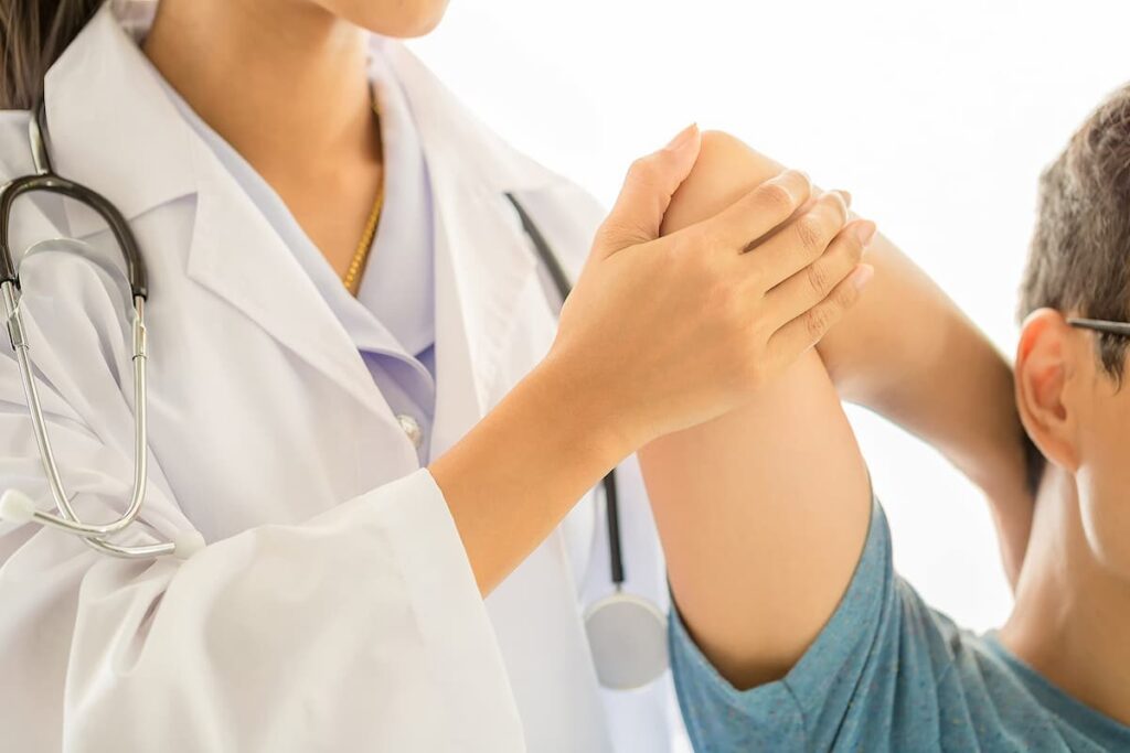 Médica tratando paciente em consultório de fisioterapia.