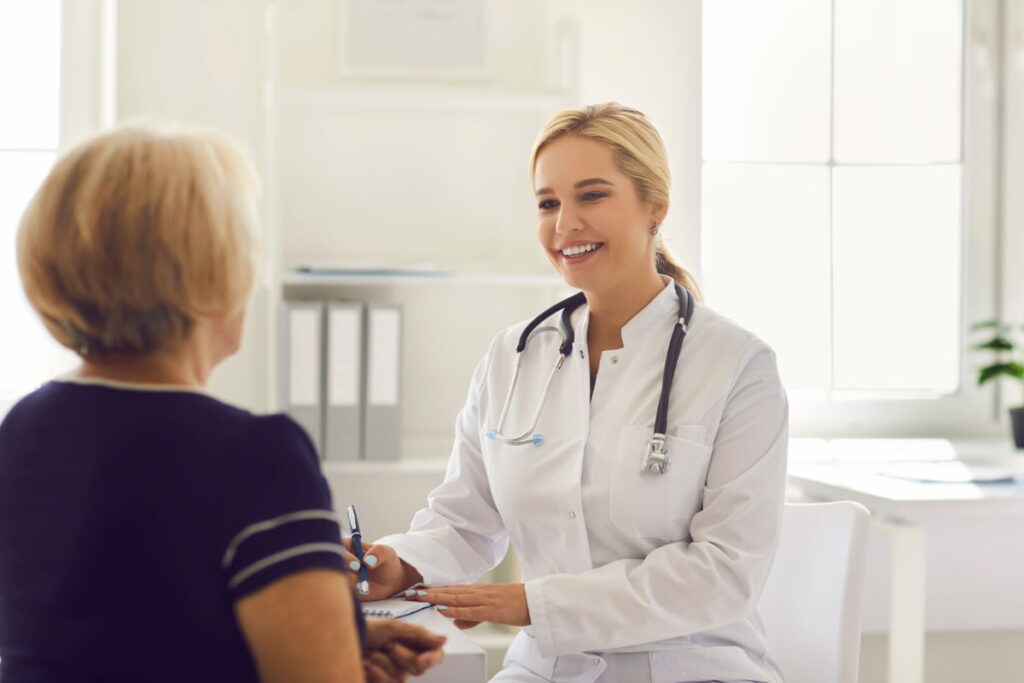 Médica sorridente com paciente, simbolizando como captar pacientes para a clínica.