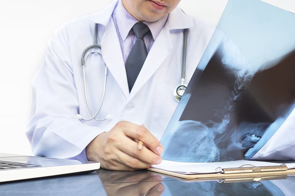 Médico examinando um exame de raio-x no consultório de ortopedia;