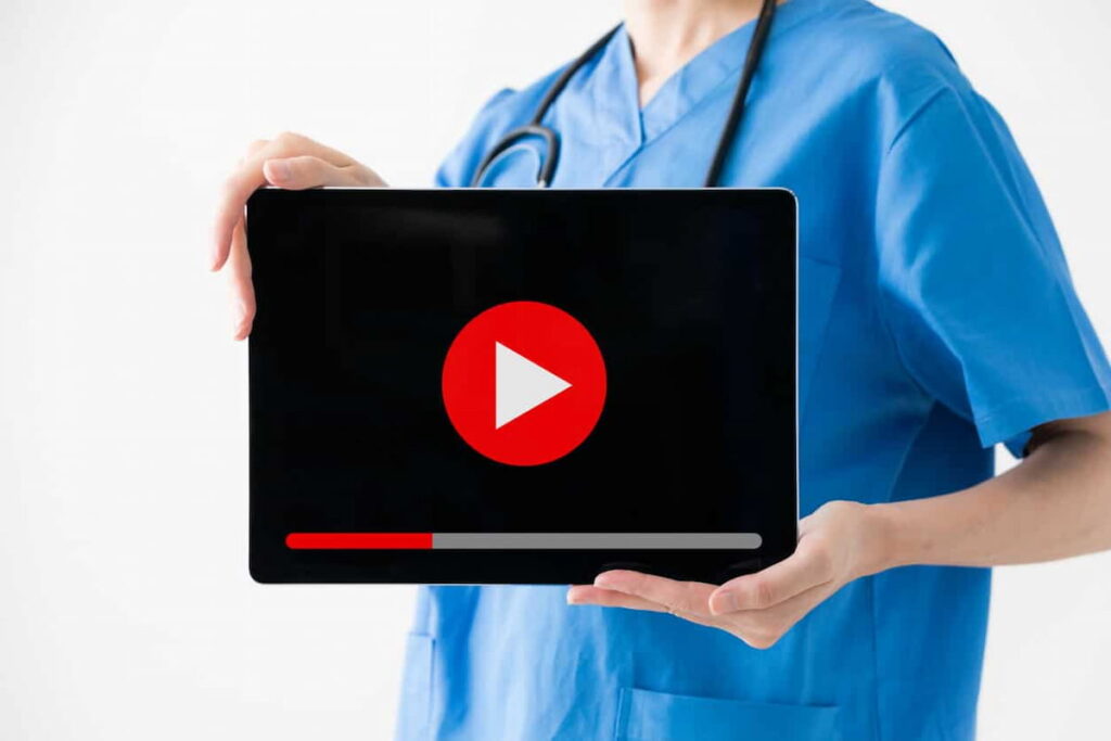 Profissional da saúde segurando laptop mostrando os filmes que todo médico deve assistir.