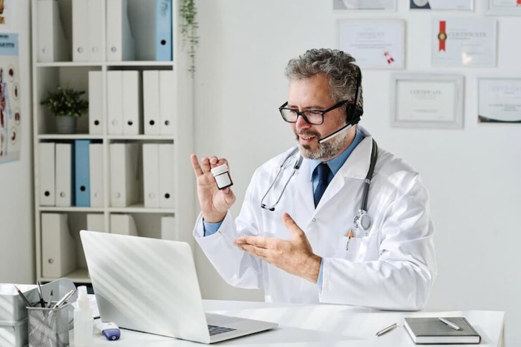 Médico fazendo telemedicina em sua mesa com laptop.
