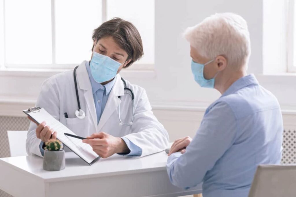 Médico atendendo paciente e analisando como preparar sua clínica para receber pacientes pós Covid-19.