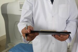 Profissional de saúde segurando um tablet com prontuário médico eletrônico, simbolizando gestão moderna de dados.