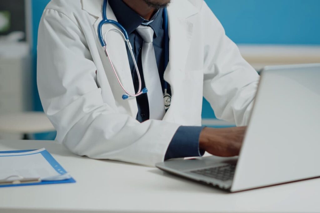 Médico usando o computador para descobrir como funcionam certificação digital e nota fscal eletrônica para médicos.