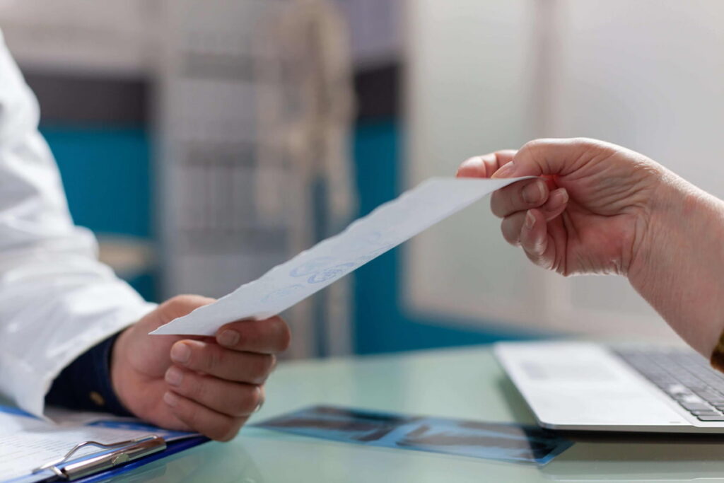 Médico entregando um relatório médico a um paciente em um consultório.