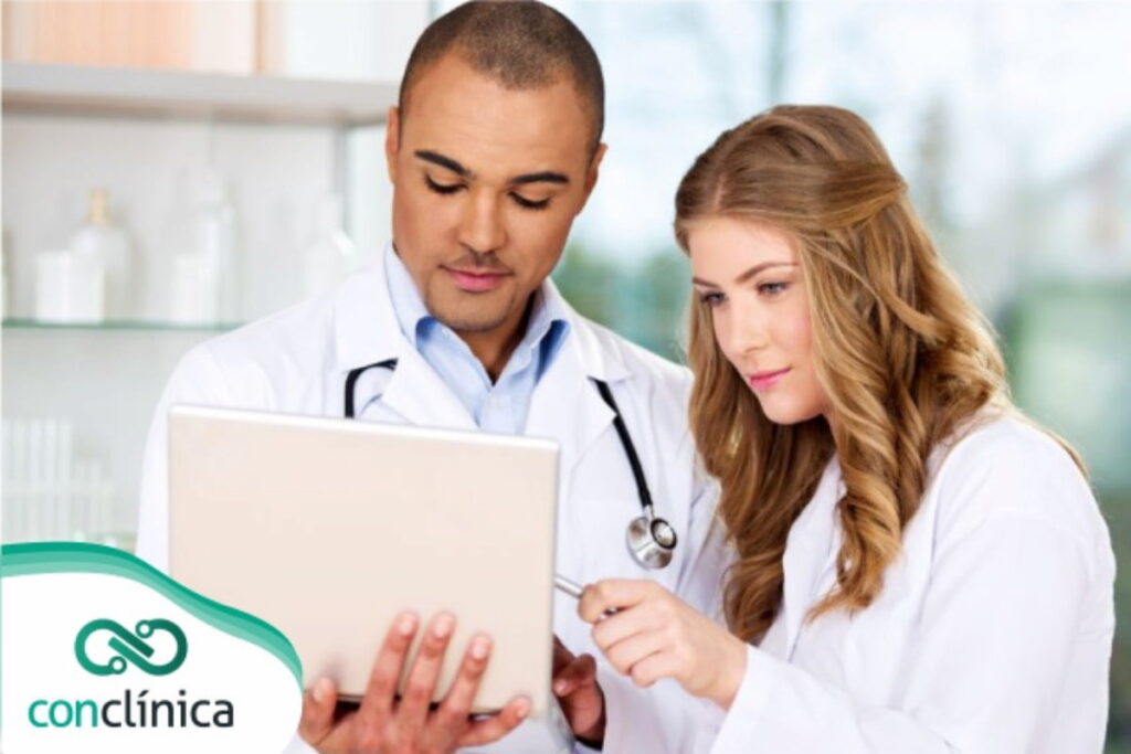 Dois profissionais de saúde analisando em um tablet a rotina de um médico.