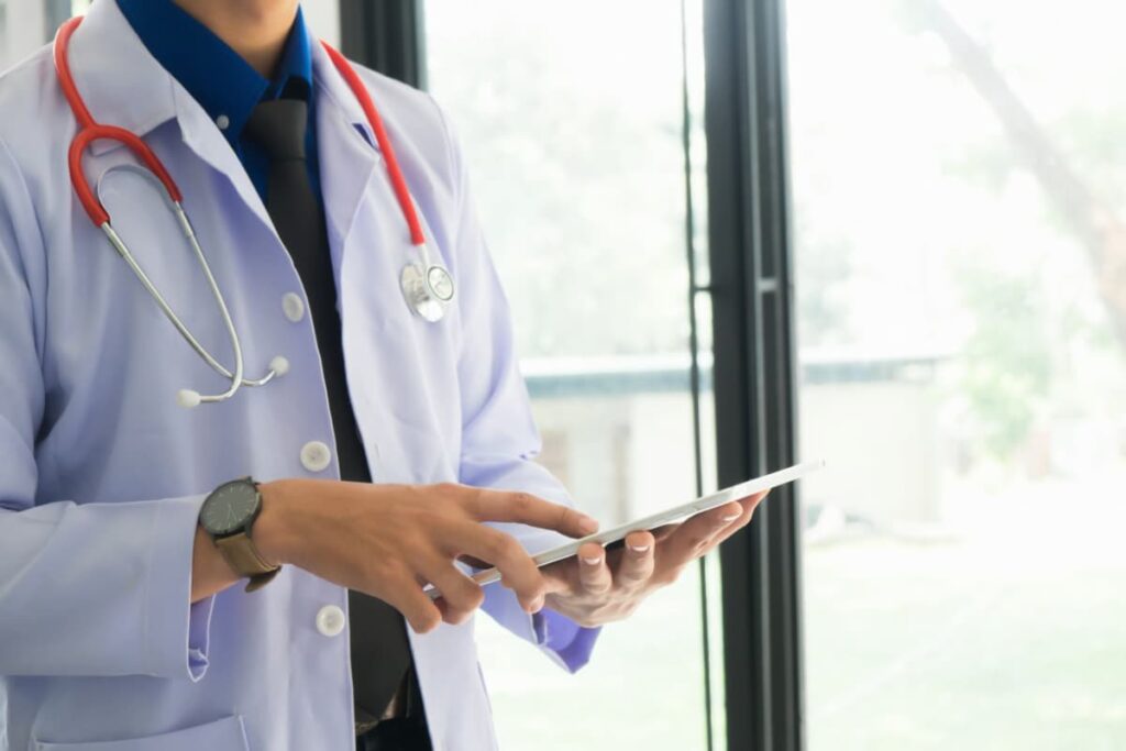 Médico usando tablet, representando a telepresença.
