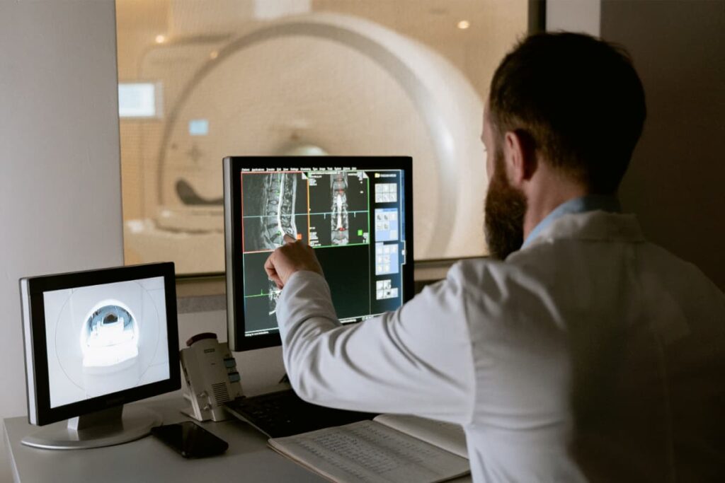 Médico analisando raio-X pelo computador, simbolizando a telerradiologia.
