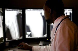 médico conferindo exames por meio da telerradiologia.