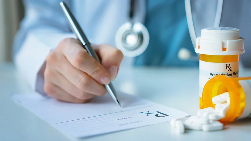 médico escrevendo em prescrição. Imagem ilustrativa para texto modelo atestado médico.