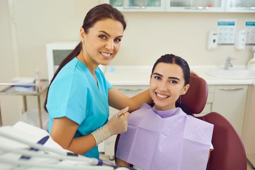 Dentista e paciente sorrindo durante consulta, simbolizando o inbound marketing para clínicas.