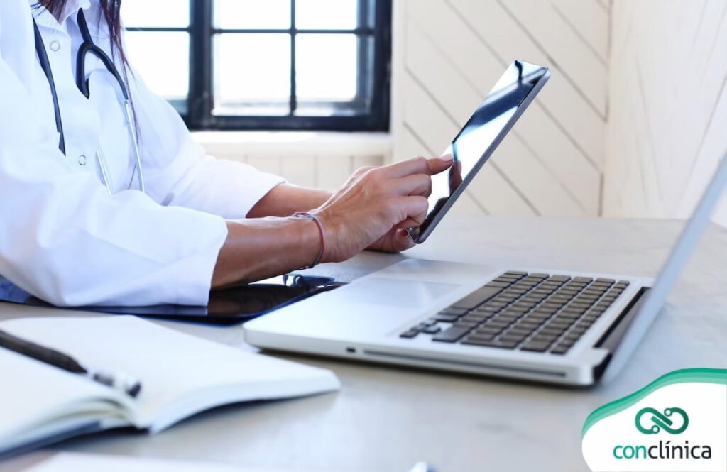Profissional de saúde usando um software de prontuário eletrônico em um tablet.