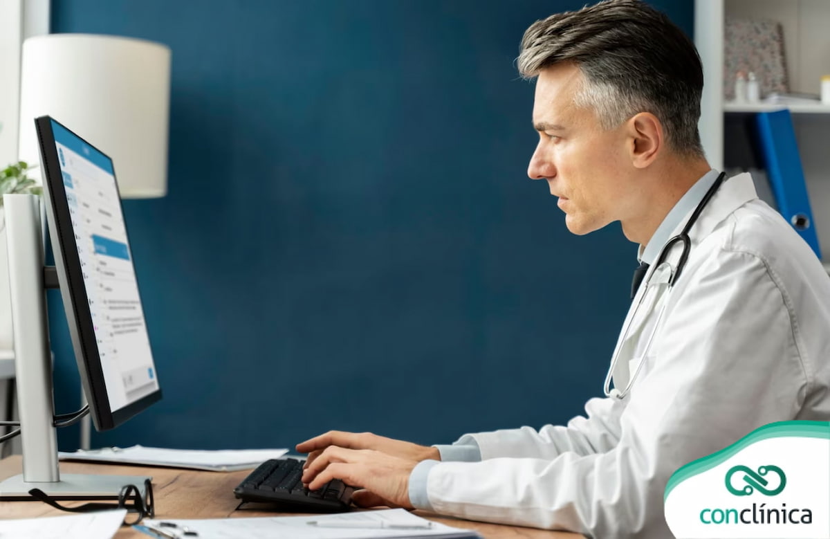 Médico digitando informações em consultório no software para gestão de clínicas médicas.