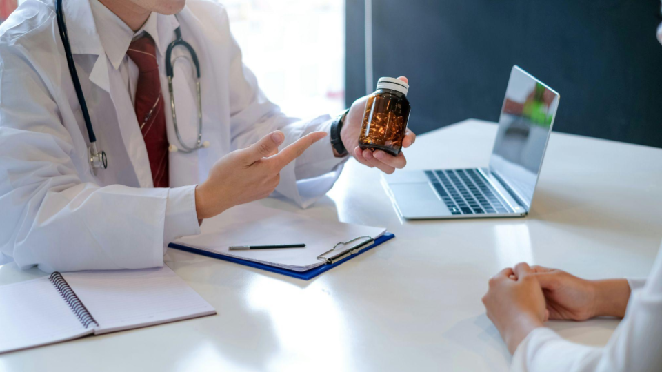 Esta imagem retrata uma consulta médica ou profissional de saúde, focada no momento da orientação sobre um tratamento.