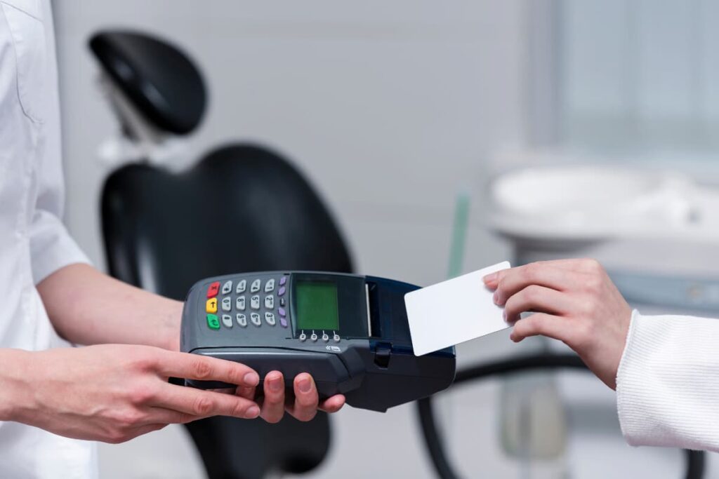 Pessoa paga com máquina de cartão menor taxa para clínicas.
