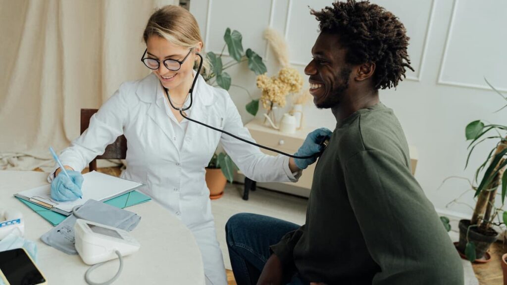 Fotografia de uma médica atendendo um paciente.