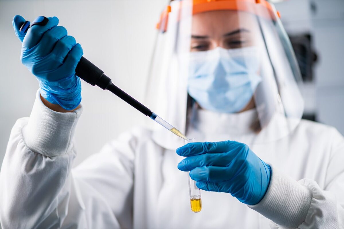 Médica manuseando material biológico e utilizando equipamentos para evitar risco biológico