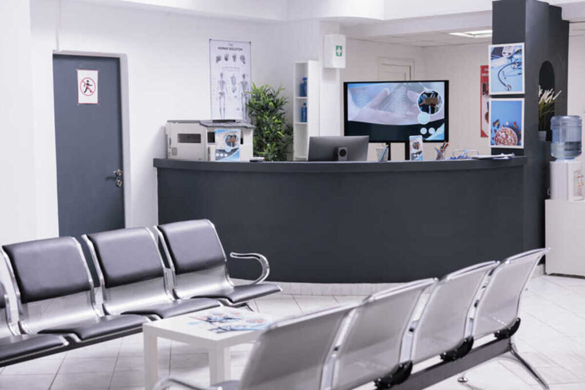 sala de espera de um consultório, com cadeiras de ferro e uma bancada