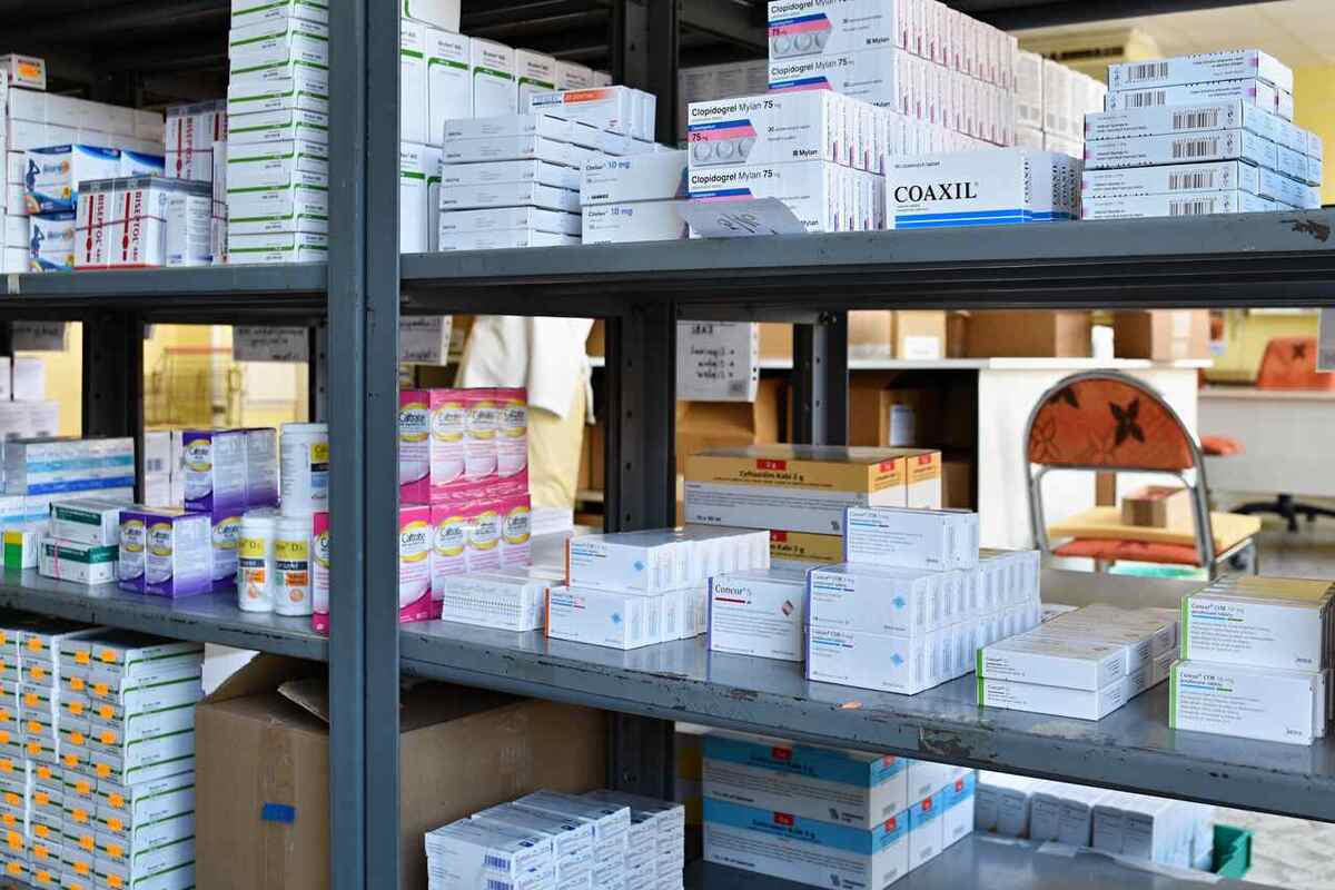 Remédios que passam por um controle de estoque de medicamentos arrumados em uma estante de ferro