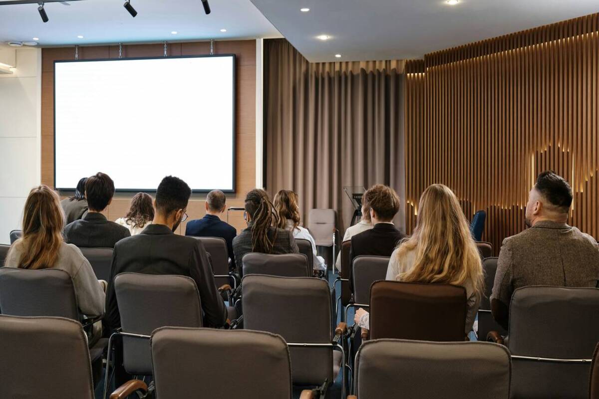 medicos participam de um congresso medico em um sala, com um telao em branco
