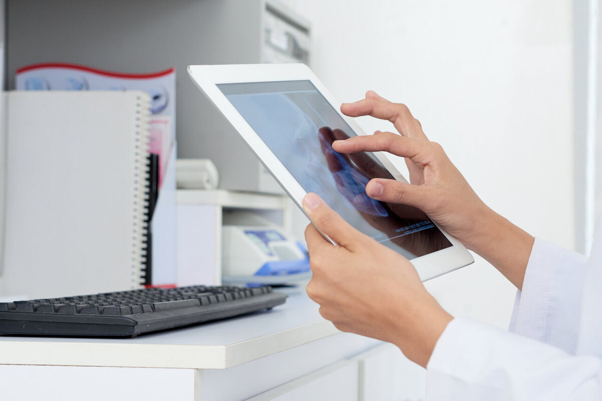 médico de jaleco branco usa o sistema de controle de estoque em um tablet