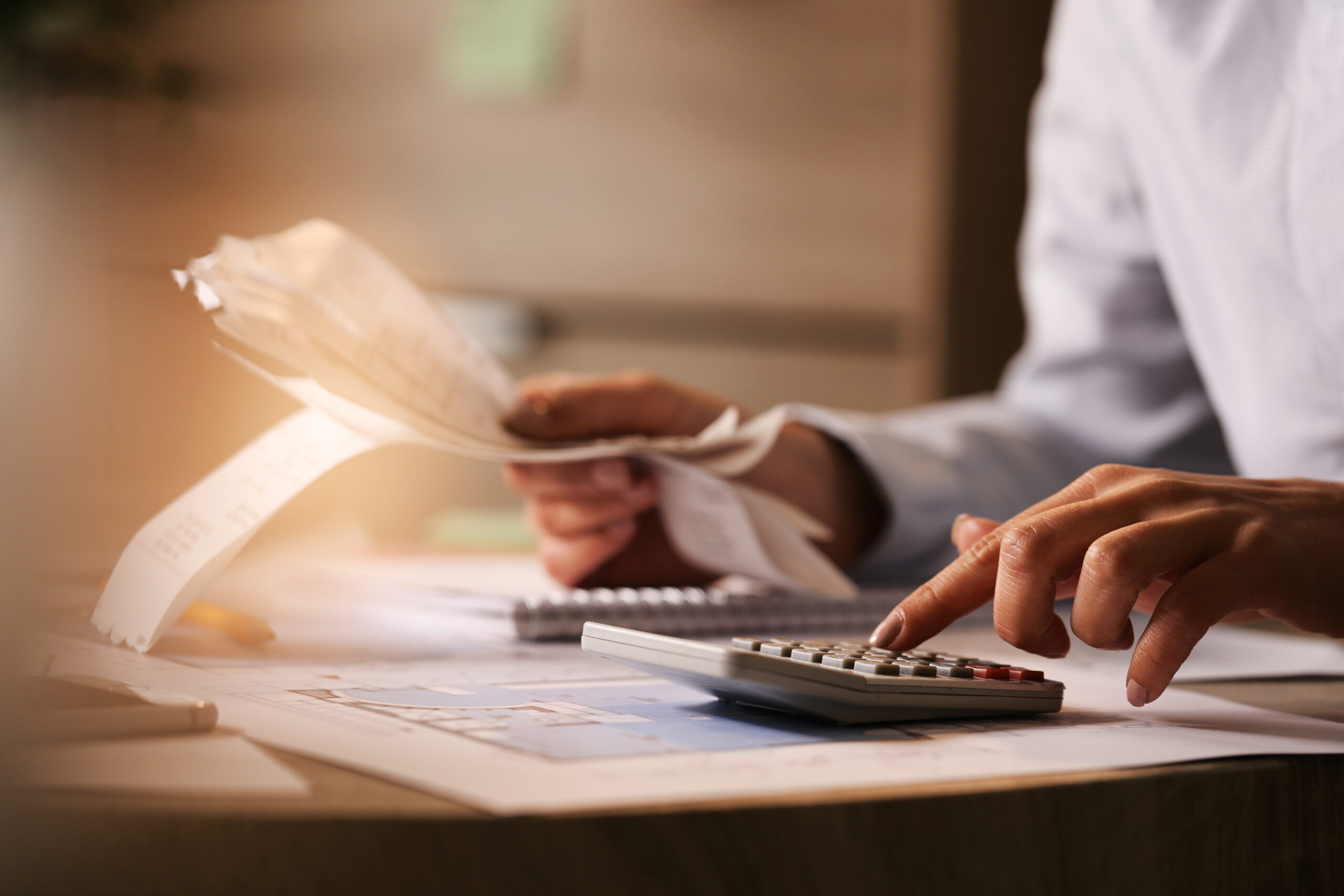 Pessoa usando uma calculadora em uma mesa para fazer contas - Foto: Freepik