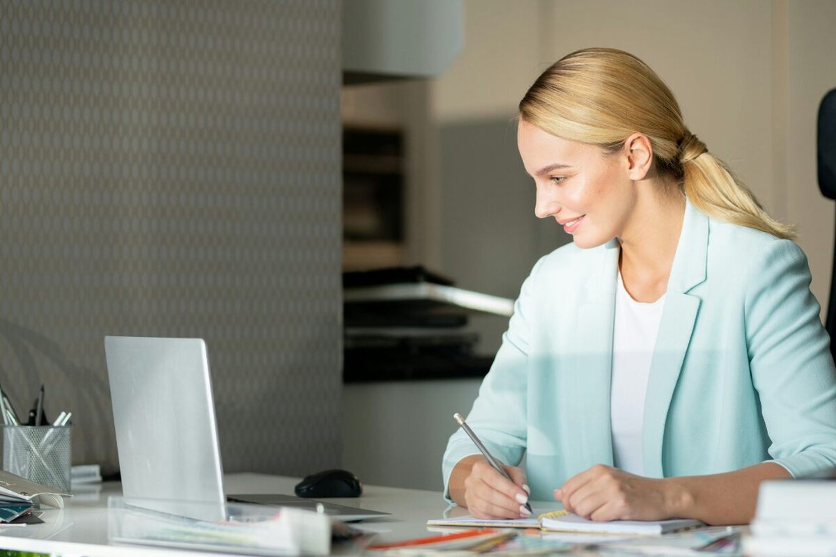 gestora de clínica sorrindo para computador, que conta com o backup automático de dados do conclínica