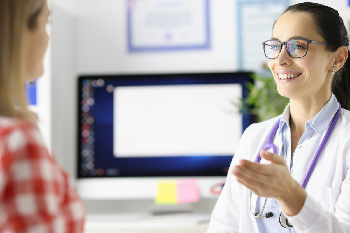 Essa foto mostra uma interação entre uma médica e uma paciente em um consultório.