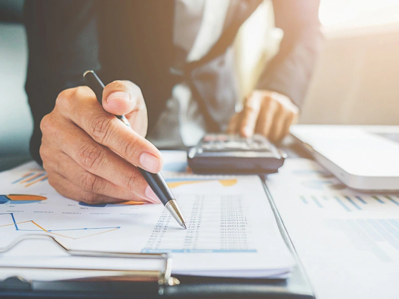 gestor calculando o fluxo de caixa em cl&iacute;nicas m&eacute;dicas e analisando dados no papel