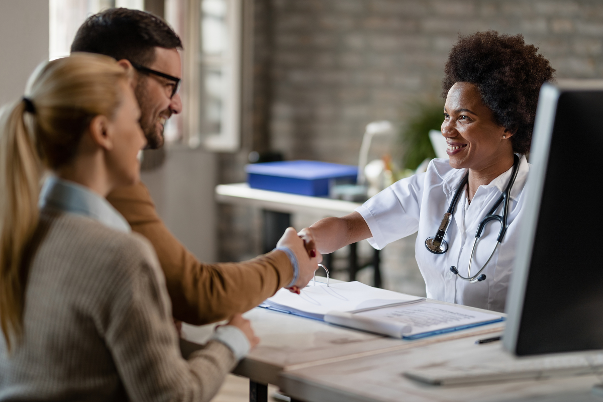 A imagem captura um momento de interação cordial e profissional em um ambiente que parece ser um consultório médico.