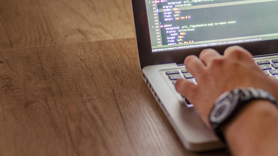 Esta imagem captura uma perspectiva próxima e técnica do trabalho de desenvolvimento web ou design de interfaces.