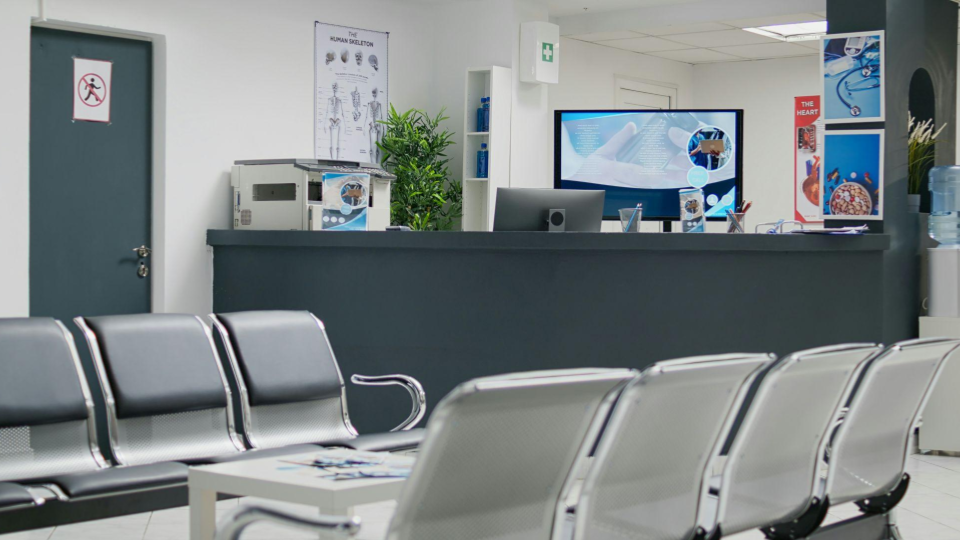 Recepção de clínica médica com sala de espera organizada e vazia, balcão de atendimento e ambiente moderno, representando gestão de agenda médica, organização dos atendimentos e otimização da ocupação da clínica.