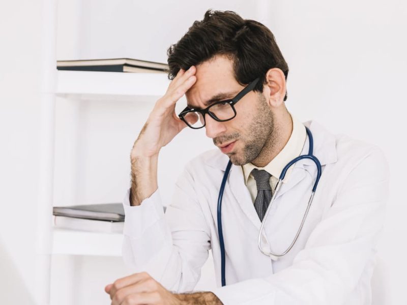 Médico estressado, simbolizando a síndrome de burnout em médicos residentes.