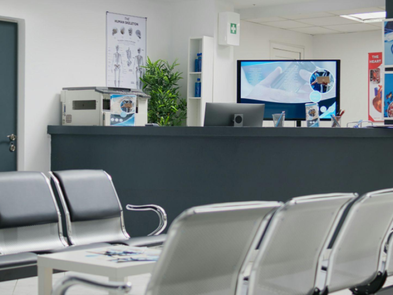 Recepção de clínica médica com sala de espera organizada e vazia, balcão de atendimento e ambiente moderno, representando gestão de agenda médica, organização dos atendimentos e otimização da ocupação da clínica.