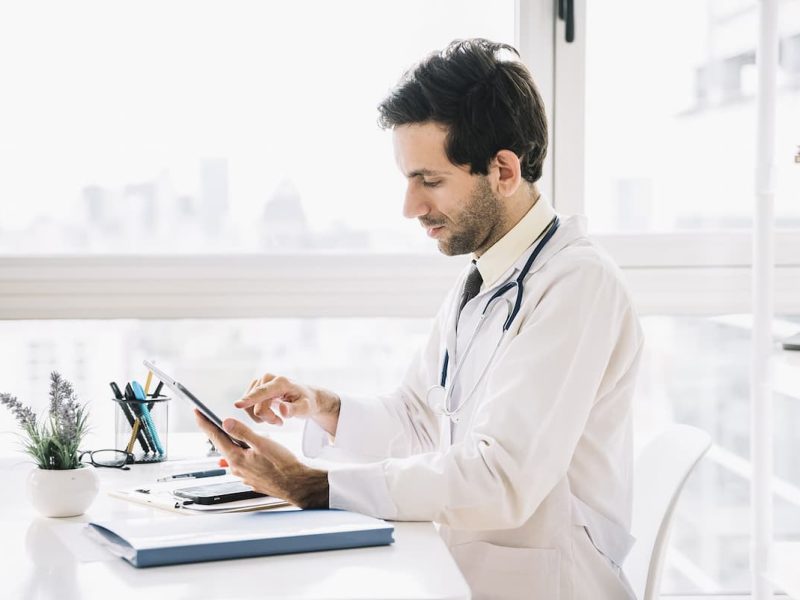 Médico fazendo um agendamento online no tablet.