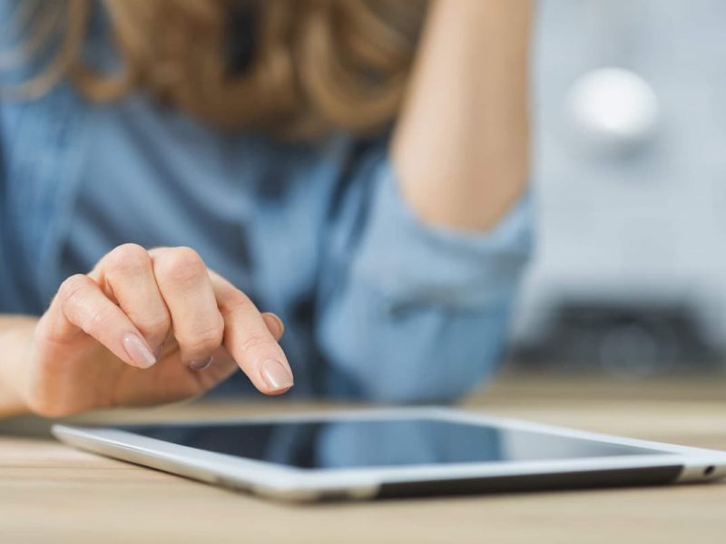 Médica fazendo agendamento online em tablet para sua clínica médica.