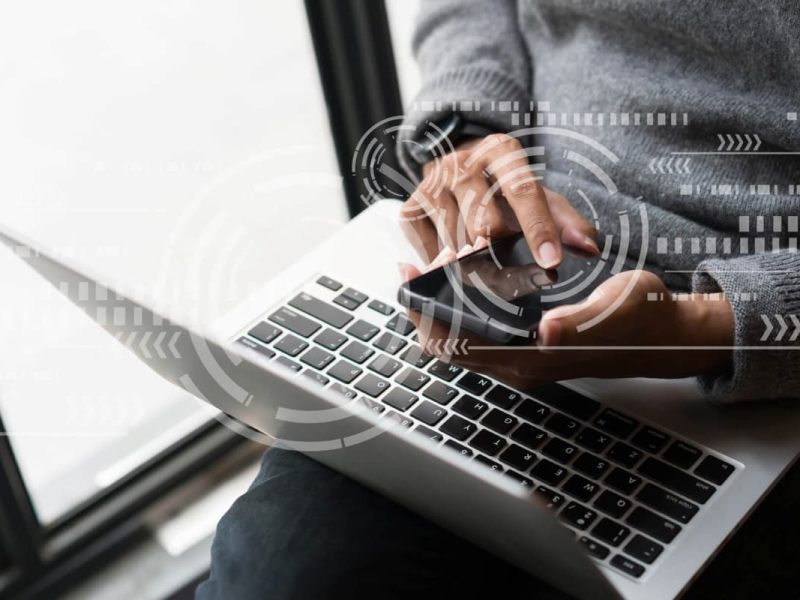 Pessoa usando laptop com ícones digitais sugerindo agendamento online.