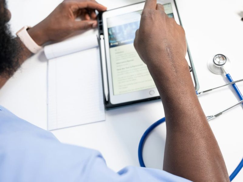 Fotografia de um médico preenchendo um CID em atestado médico de forma eletrônica, com um tablet.
