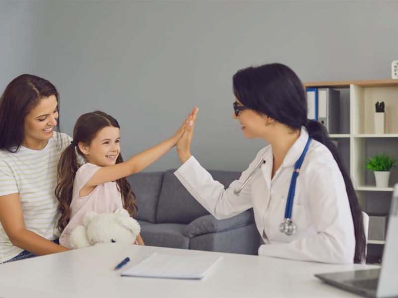 Médica sorrindo com duas pacientes em uma clínica ampliada.