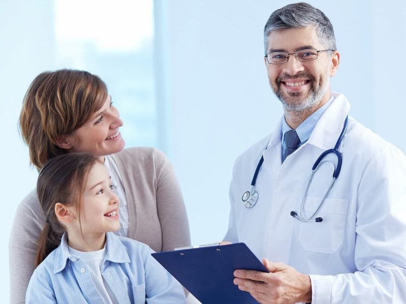 Médico sorrindo com pacientes, representando como atrair pacientes para clínicas médicas.