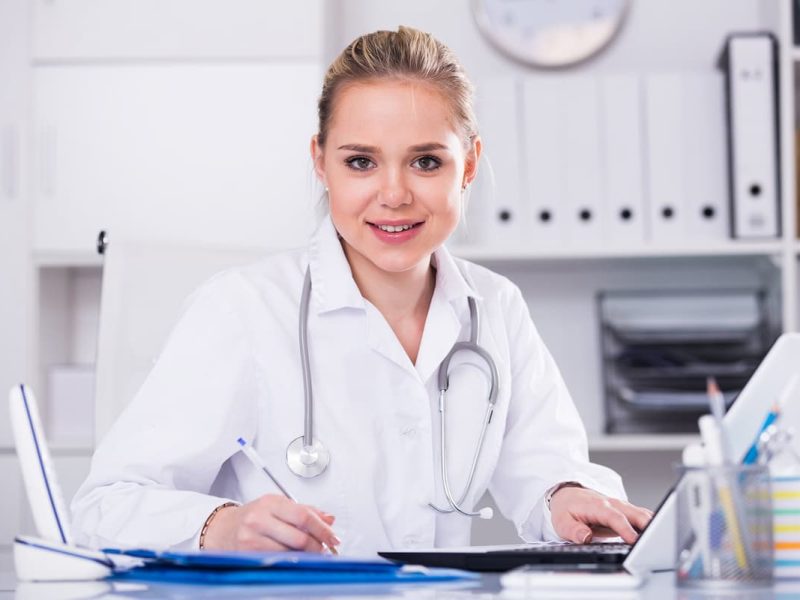 Profissional da saúde sorridente analisando como expandir linhas de crédito no consultório médico.