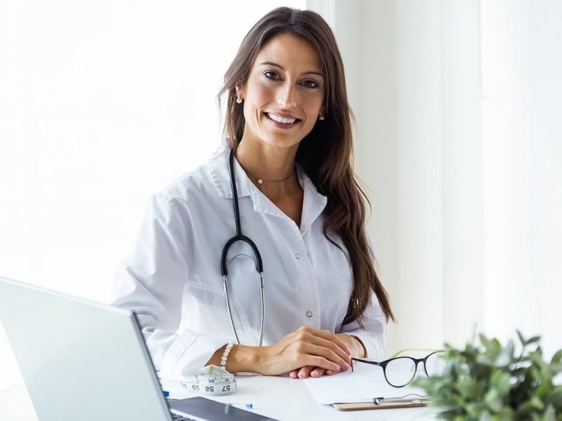 Profissional da saúde em frente ao computador para ensinar como montar uma clínica médica do zero.