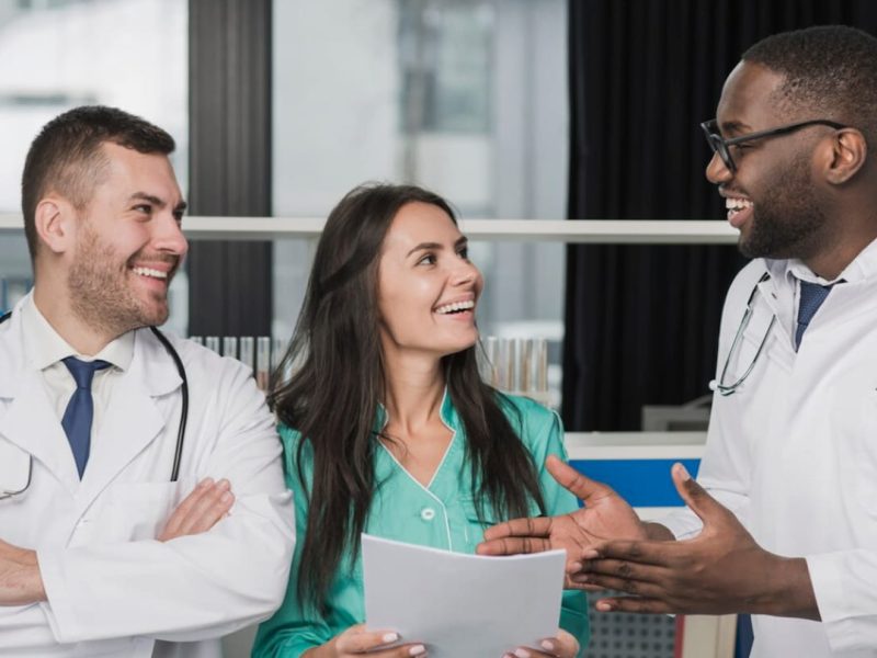 Grupo de 3 médicos conversando sobre como montar uma clínica multidisciplinar.